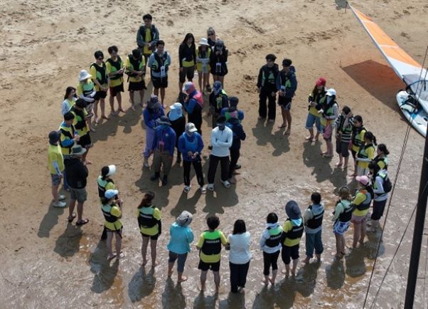 HAIC students standing in a circle on beach