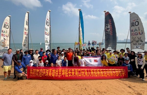 Group of HAIC students and sailboats in front of ocean