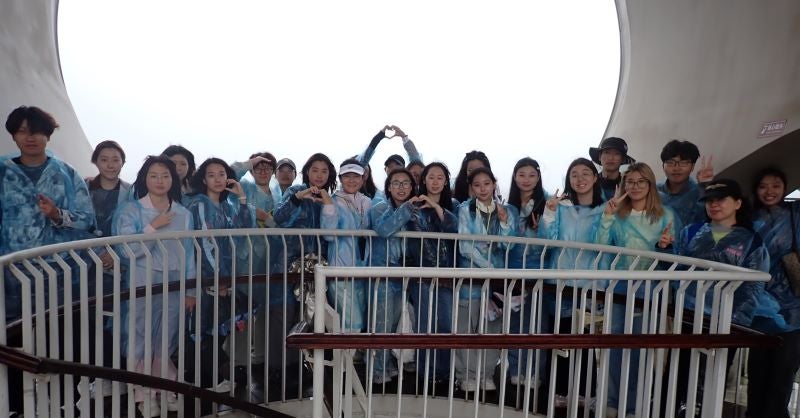 Group of HAIC students standing at top of circular stairs