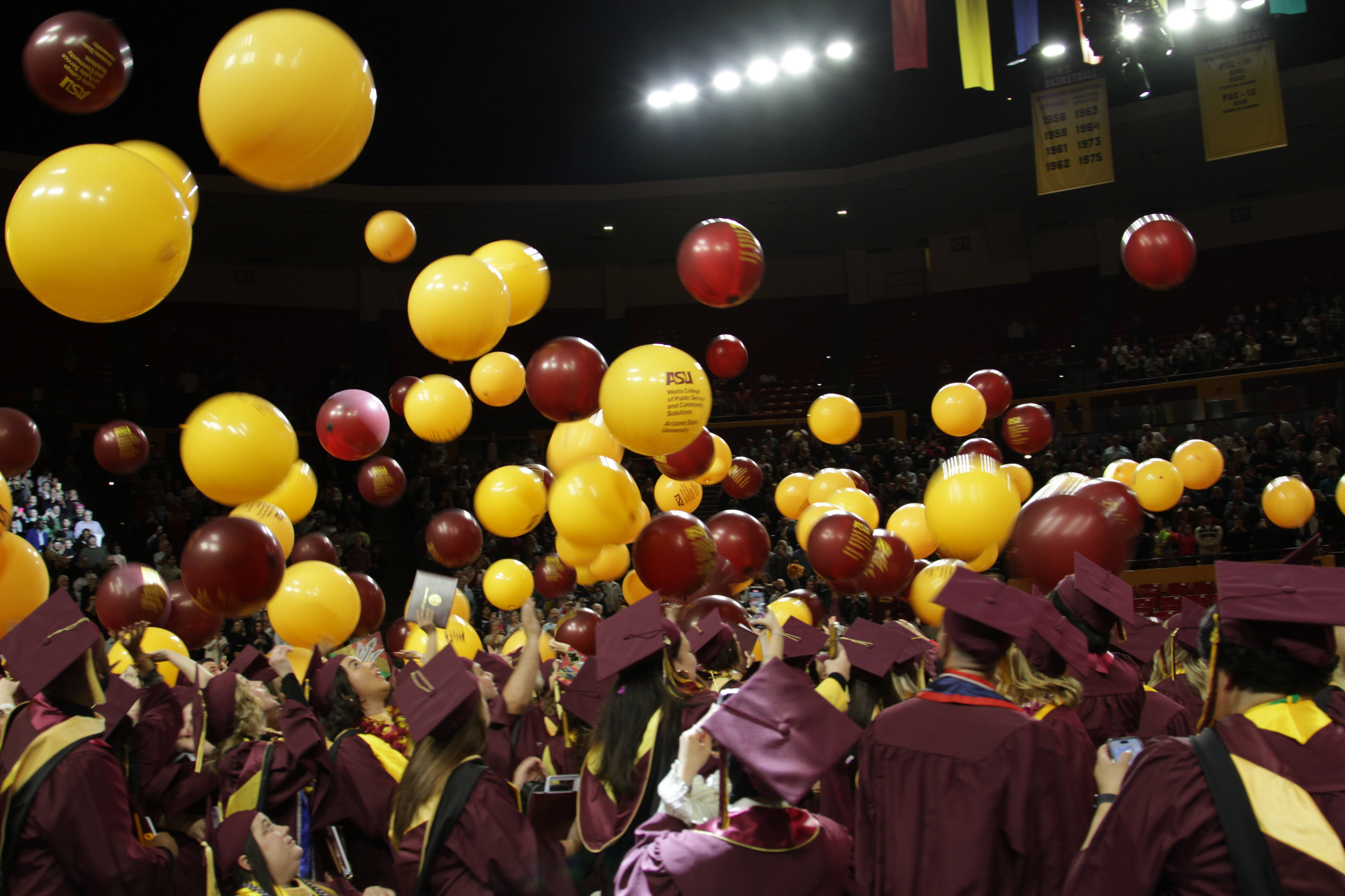 Watts convocation ceremony with gold and maroon balloons and graduates in caps and gowns