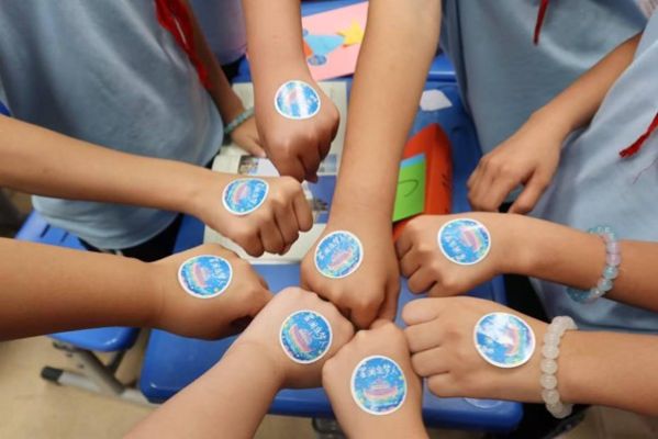 Children proudly sporting stickers on their hands