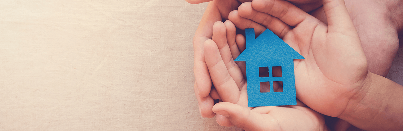 hands holding a paper house