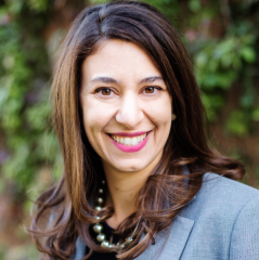 Andrea Whitsett headshot - fair-skinned woman, smiling, brown hair, gray blazer, black shirt, pearl necklace