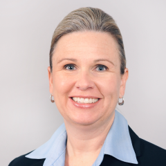 Dean Cynthia Lietz headshot - fair-skinned woman, brown hair, smiling, blue collared shirt